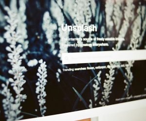 Екран комп'ютера з домашньою сторінкою Unsplash та пошуковим рядком.